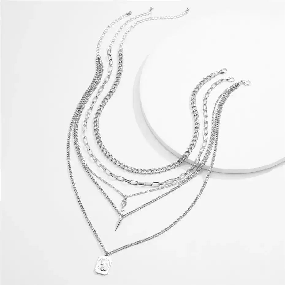 Close-up of silver layered chain necklaces with pendants, goth statement jewelry