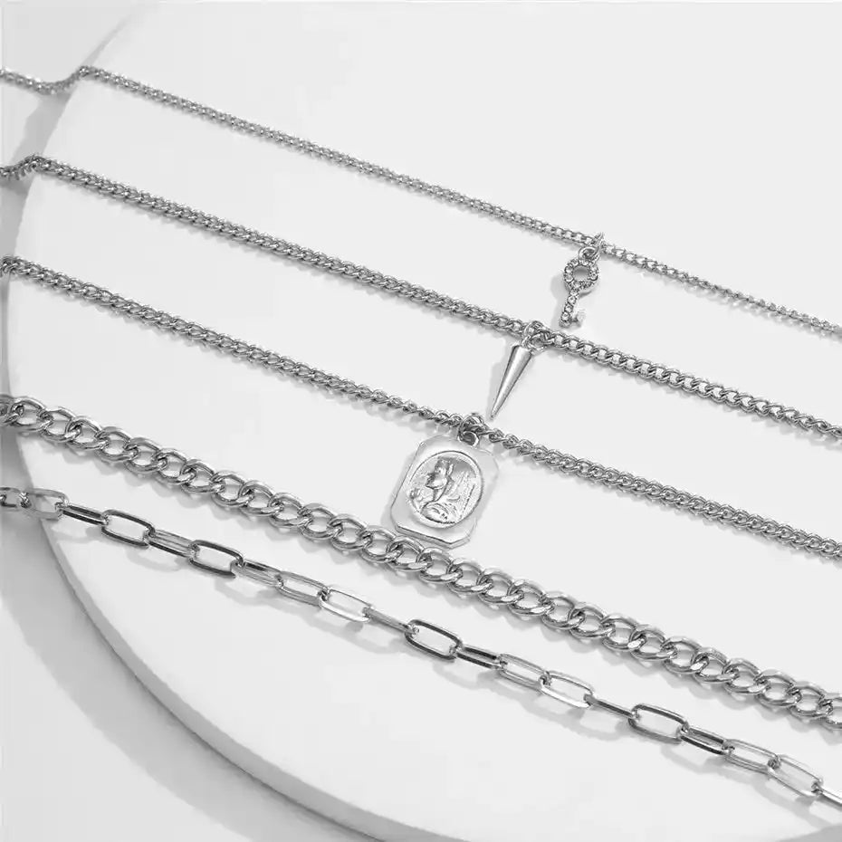 Layered silver chain necklaces with pendants and charms
