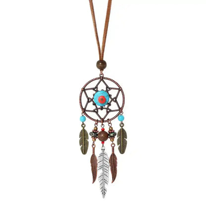 Long bohemian feather pendant necklace with turquoise & ethnic metalwork on a leather rope chain. Lightweight, durable, festival-ready. Ships from Pedlar's Attic.