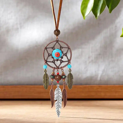 Long bohemian feather pendant necklace with turquoise & ethnic metalwork on a leather rope chain. Lightweight, durable, festival-ready. Ships from Pedlar's Attic.