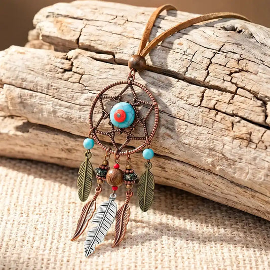 Long bohemian feather pendant necklace with turquoise & ethnic metalwork on a leather rope chain. Lightweight, durable, festival-ready. Ships from Pedlar's Attic.